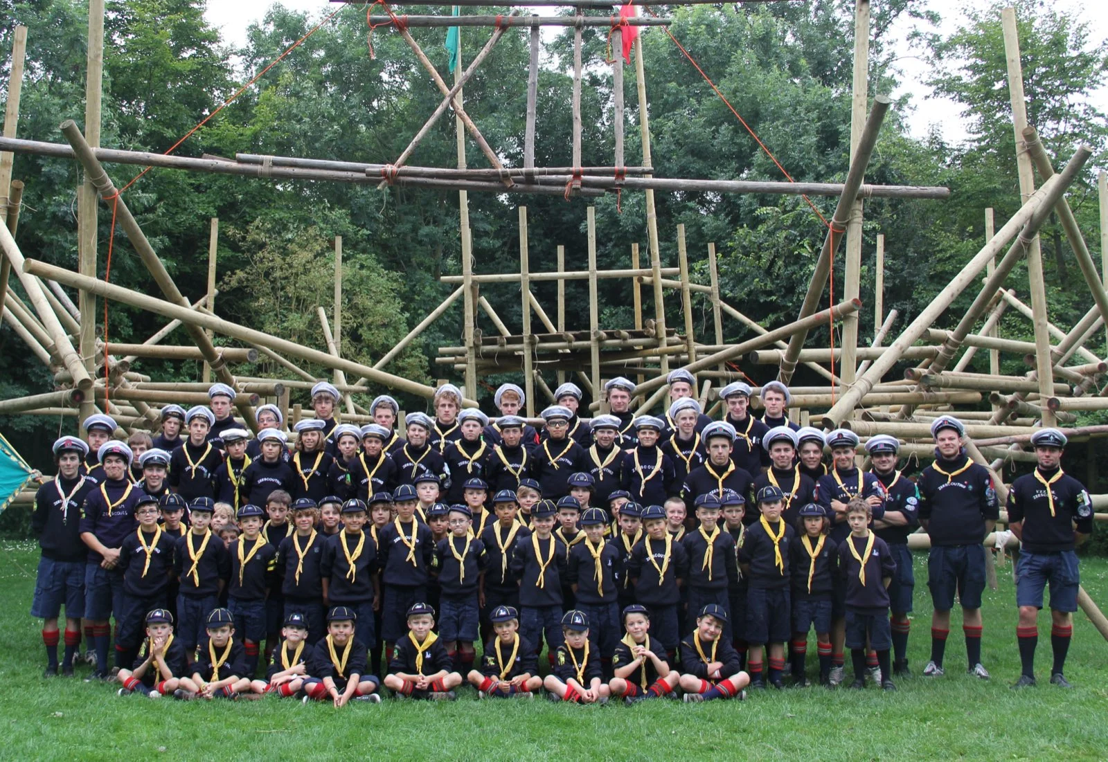 Groepsfoto van de hele 13e Sint-Joris voor een grote zelfgebouwde houten toren