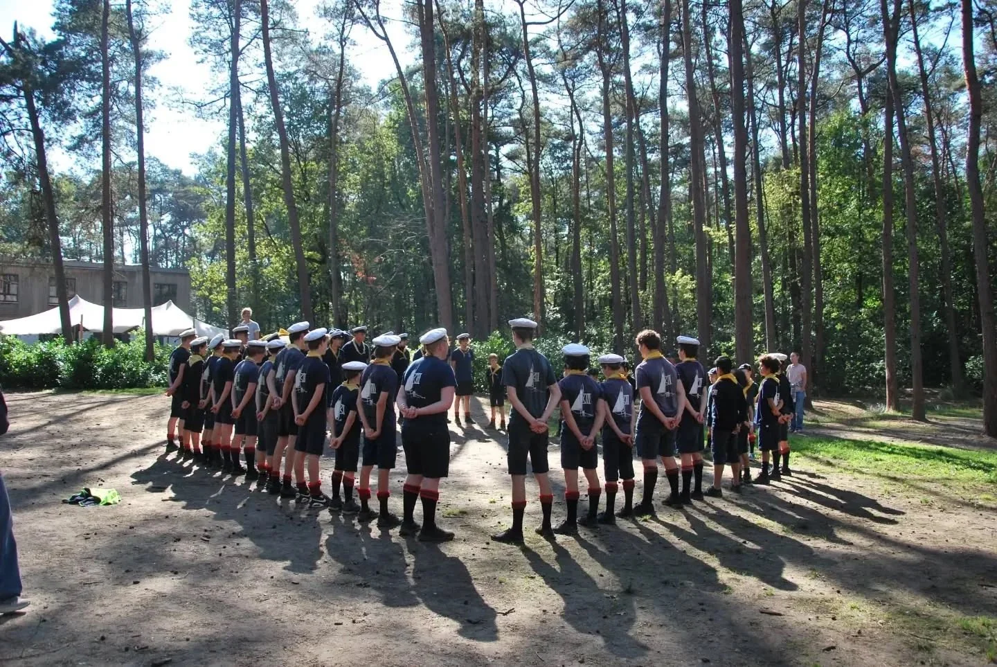 De hele groep staat in een grote kring in het bos tijdens het overgangsweekend